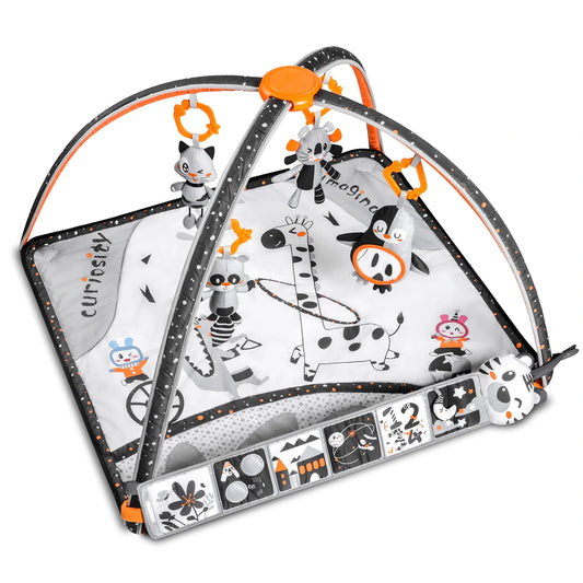 Black and white baby play gym with pops of orange, featuring soft hanging rattles shaped like animals and a printed giraffe play mat with high-contrast designs for newborn visual stimulation.