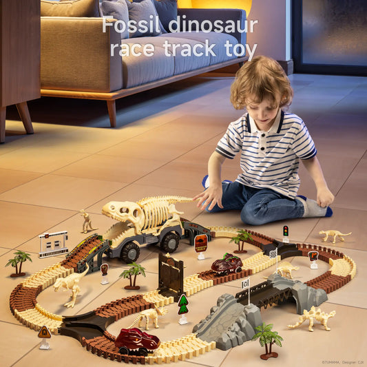 Young child playing with a fossil dinosaur race track toy set, featuring a large T-Rex skeleton truck, flexible tracks, miniature dinosaur fossils, race cars, road signs, and tropical accessories in a cozy indoor setting.