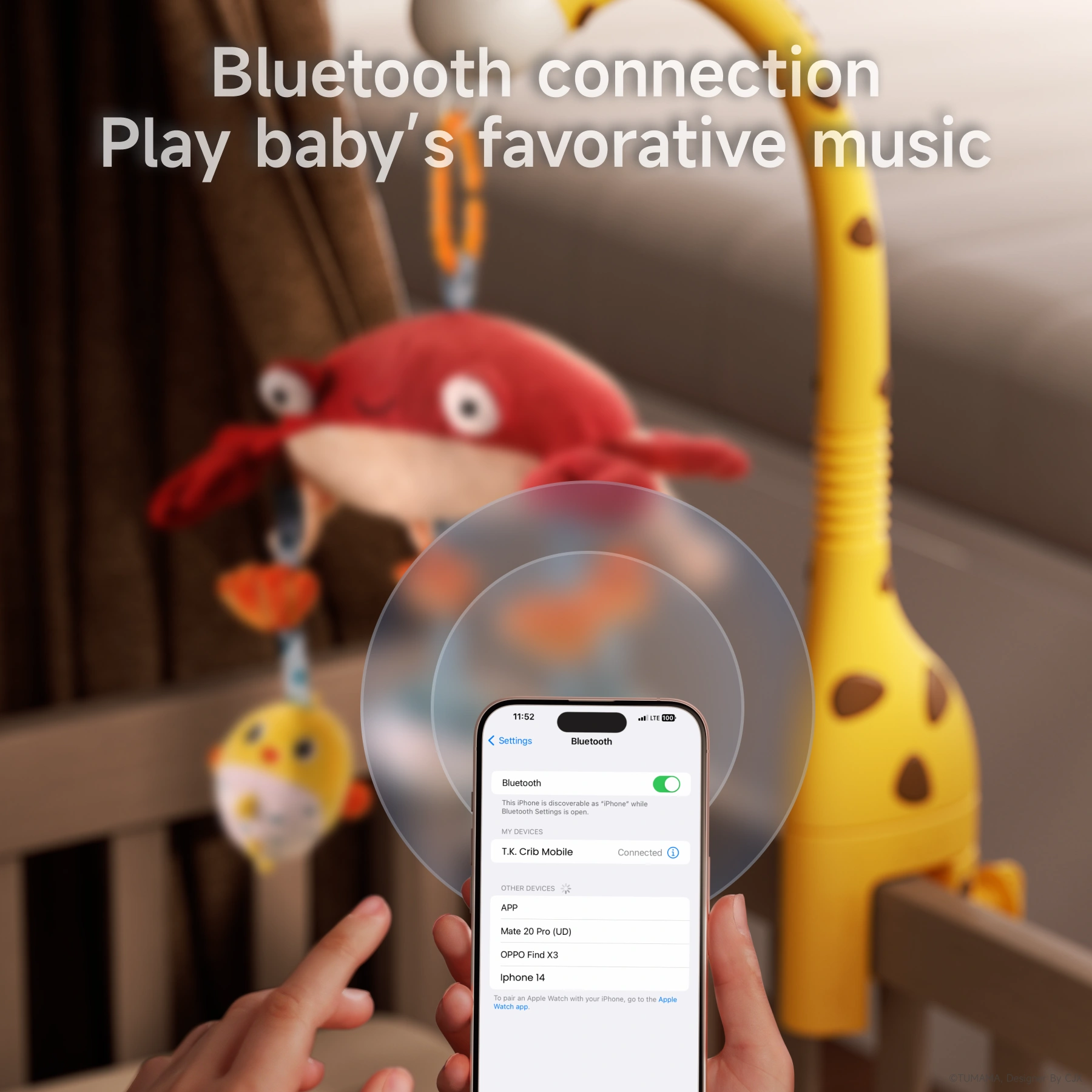 Close-up of a hand holding a smartphone showing Bluetooth settings, connecting to a crib mobile named 'T.K Crib Mobile', with a yellow giraffe-shaped mobile arm and hanging plush toys blurred in the background.
