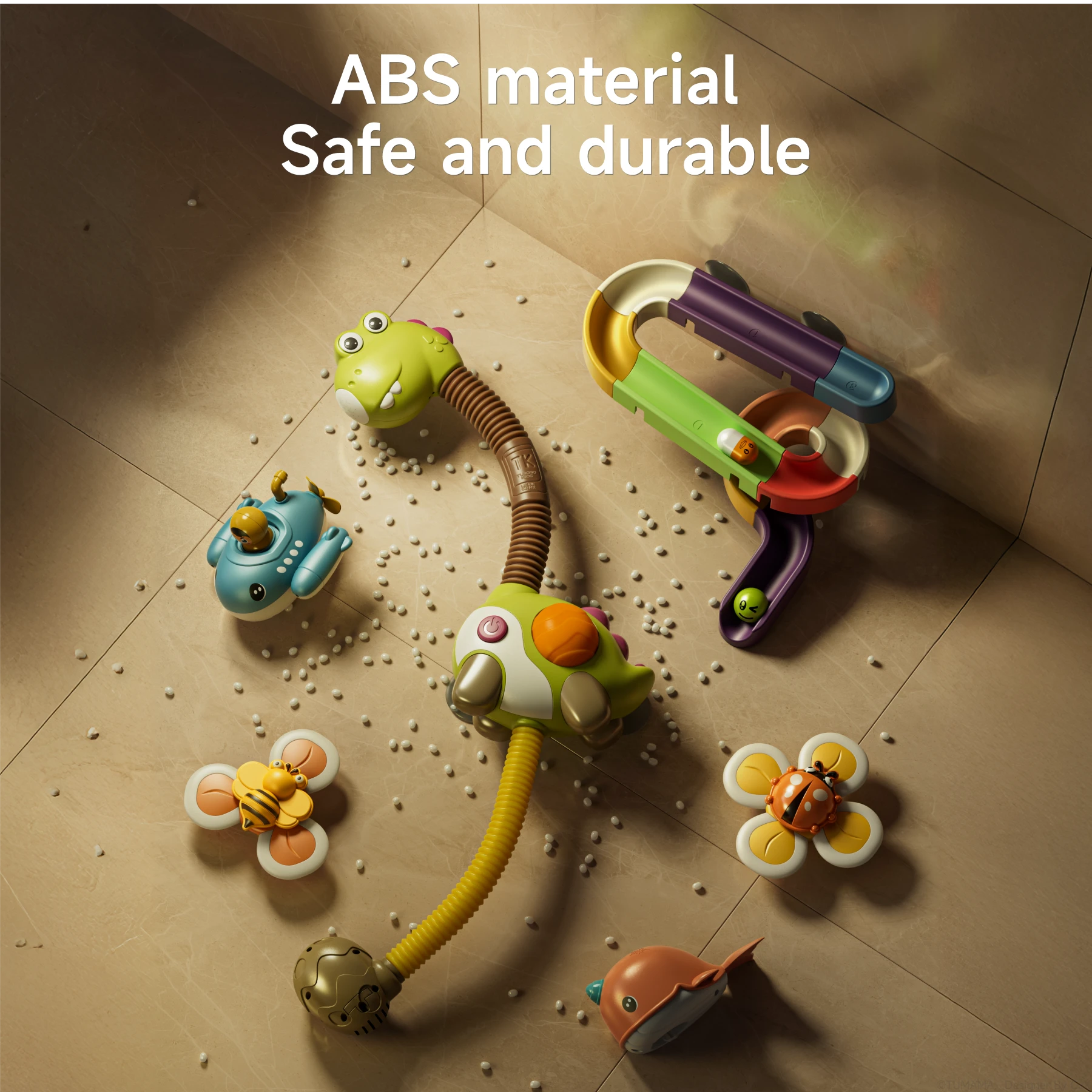 A dinosaur-themed bath toy set is displayed disassembled on a tiled surface. The set includes a dinosaur shower toy, colorful spiral track, floating submarine and narwhal toys, and suction cup flower toys with bee and ladybug designs. The text reads "ABS material Safe and durable," highlighting the toy's construction.