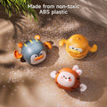 Three colorful wind-up bath toys shaped like a penguin, duck, and bunny are placed on a tiled surface surrounded. Text above reads: “Made from non-toxic ABS plastic.”