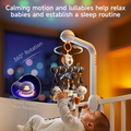 Baby lying in a softly lit white crib, reaching up to a clamp-on musical mobile with black-and-white plush woodland animals gently rotating overhead on a silent motor