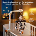 Close-up of a white clamp-on crib mobile with black-and-white plush woodland animals and trees, graphic arrows pointing to the hanging toys with icons labeled “Shake Ding Ding” and “Small Triangle BB sounds,” vertical text “Easy assemble and install,” and overlay text “Shake the hanging toy for a pleasant sound, squeeze for fun noises” against a warm nursery backdrop