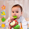 Baby chewing a green leaf-shaped teether attached to a plush toy, with inset illustrations showing star, key, leaf, and flower shaped soft teethers in various colors.