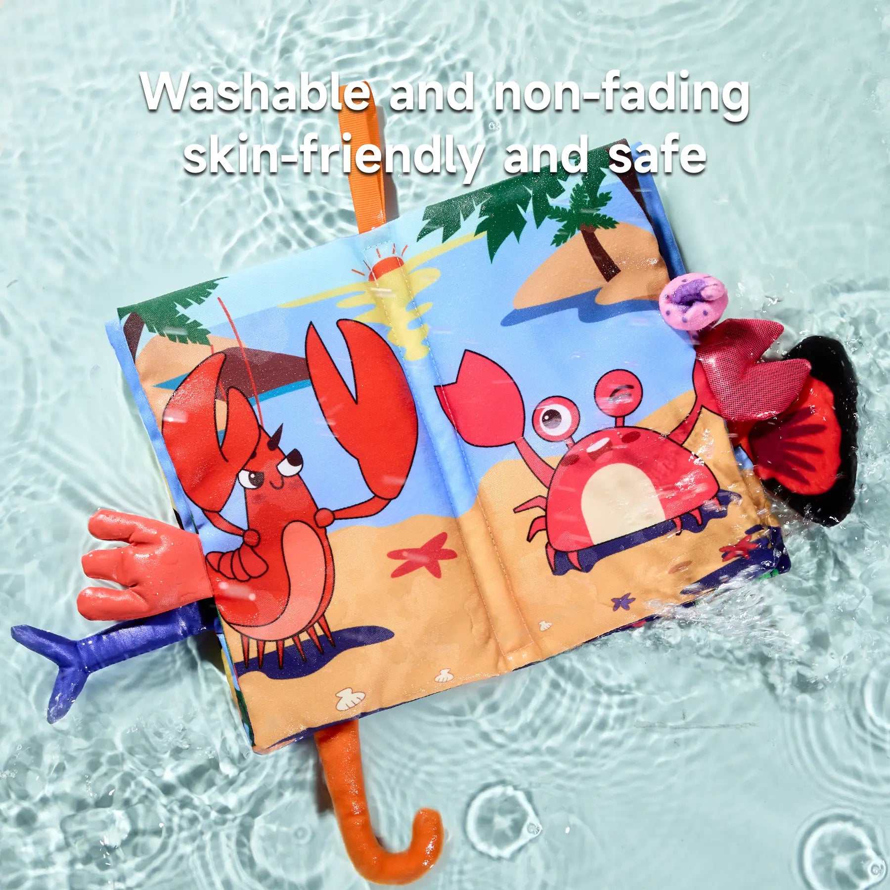 Colorful marine-themed baby cloth book floating in water, featuring cartoon illustrations of a lobster and a crab with 3D textured tails. The book is partially submerged, showcasing its water resistance. Text overlay reads: “Washable and non-fading, skin-friendly and safe,” emphasizing the book’s durability and baby-safe materials.