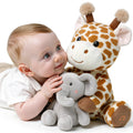 Smiling baby cuddling with a soft plush giraffe and elephant stuffed toy set on a white background; the giraffe features built-in sound functionality, ideal for interactive and comforting playtime.