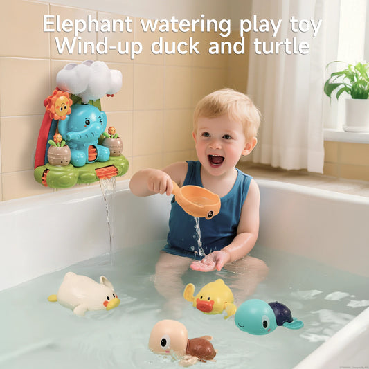 Happy toddler playing in a bathtub with an interactive elephant waterfall bath toy mounted on the wall, pouring water with a bunny-ear scoop, surrounded by wind-up floating animal toys including a duck, turtle, and octopus.