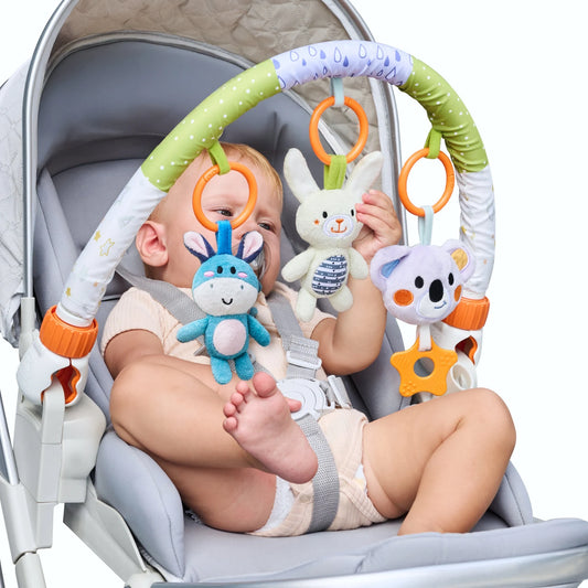 The baby is happily playing with the plush toys on the stroller arch toy