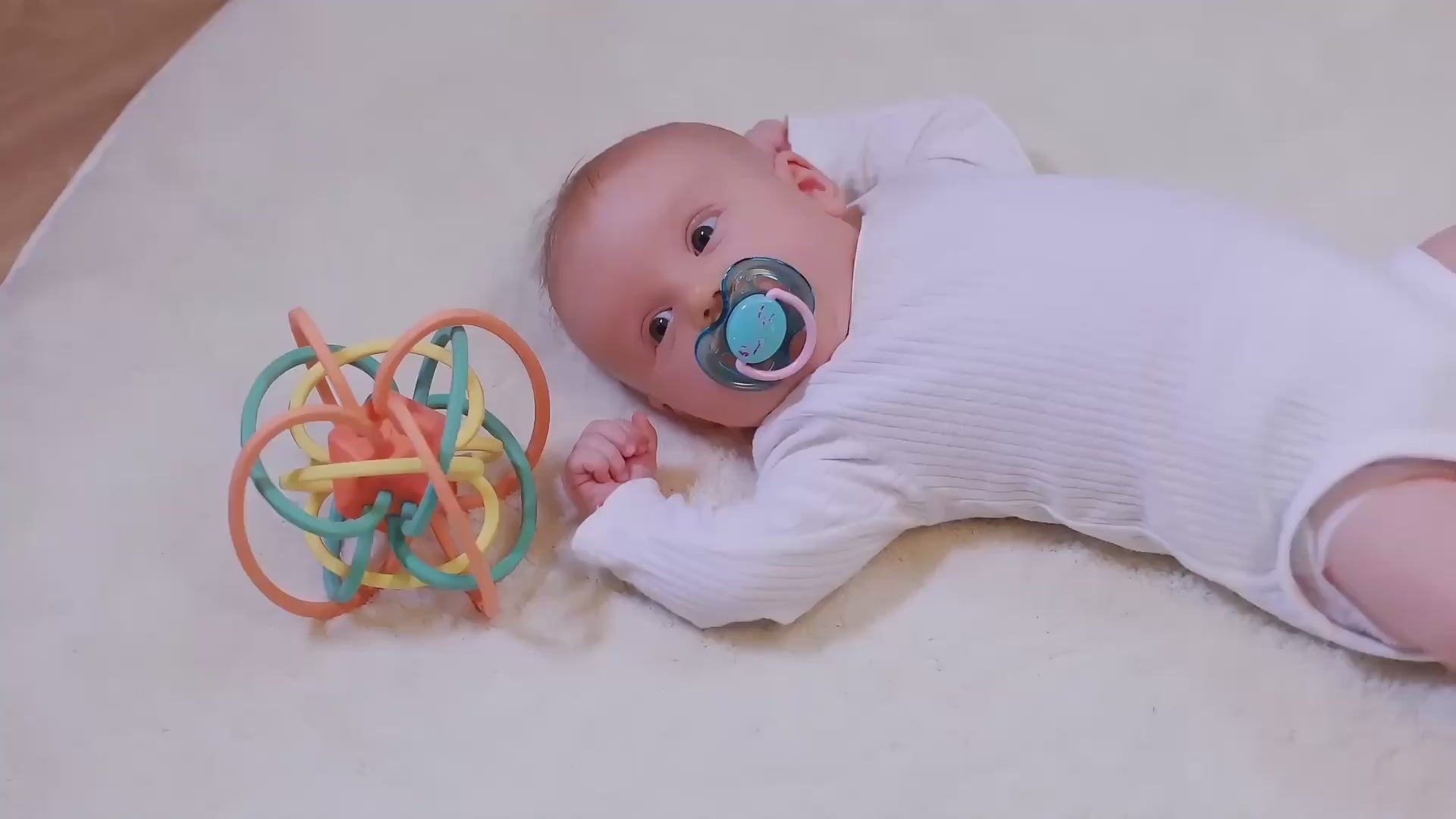 Newborn-baby-playing-with-a-montessori-hand-grasping-ball