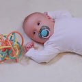 Newborn-baby-playing-with-a-montessori-hand-grasping-ball