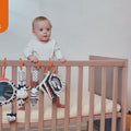 Baby-playing-with-his-black-and-white-plush-toys-in-crib