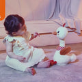 Video of baby girl playing with plush duck toy that moves neck and sings